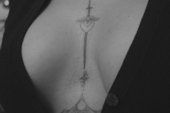 ally-alien-mikrorealizm-dotwork-miecz-ornamenty-tatuaz-miedzy-piersiami-wroclaw